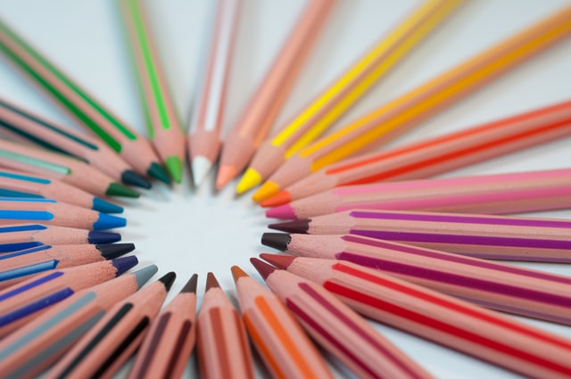 pencils of different colours places on a table in a circle