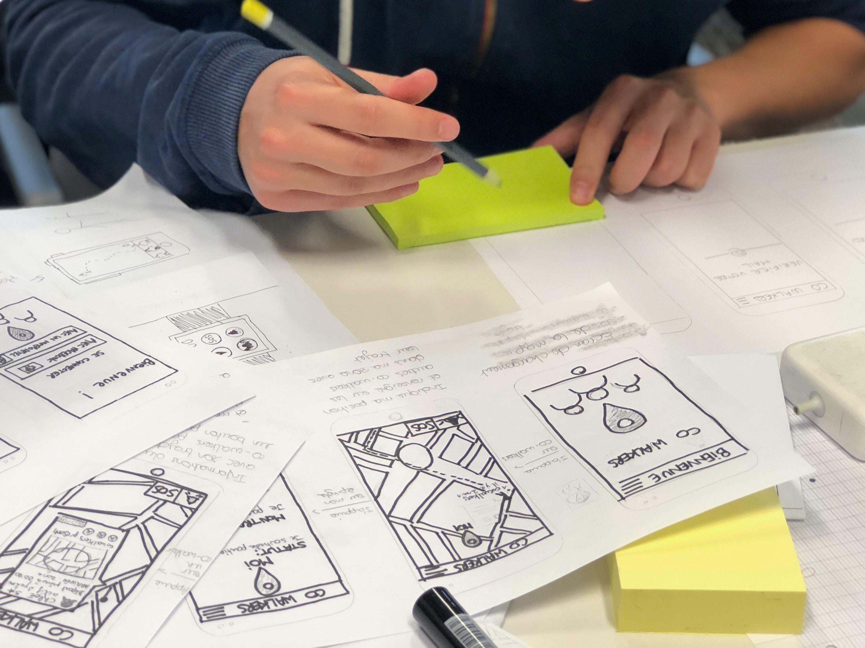 person drawing on white paper sheets
