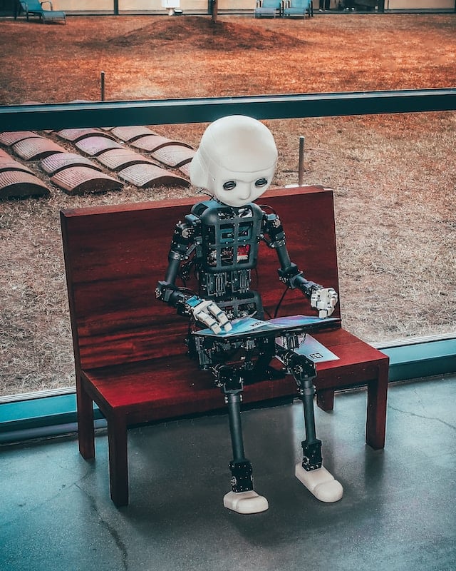 Robot sitting on a bench reading