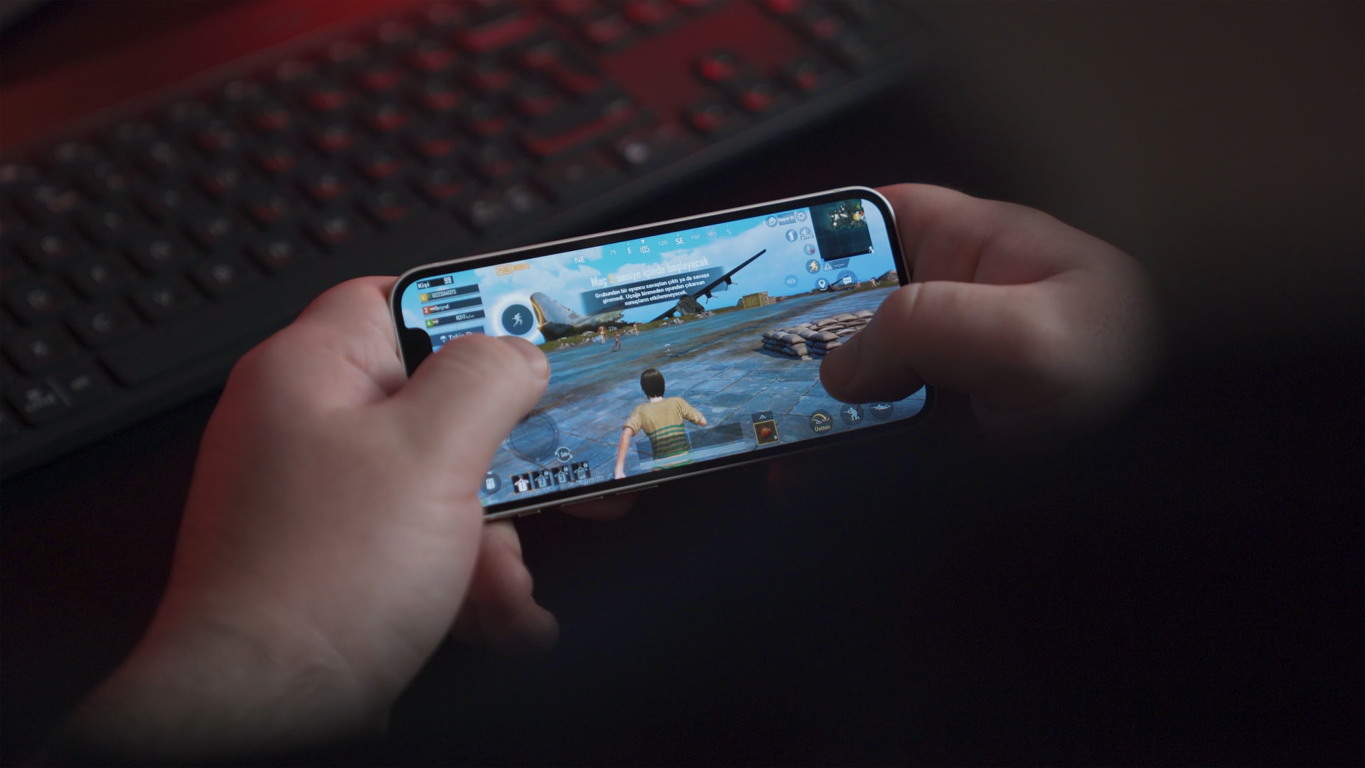 person holding a smartphone and playing a videogame